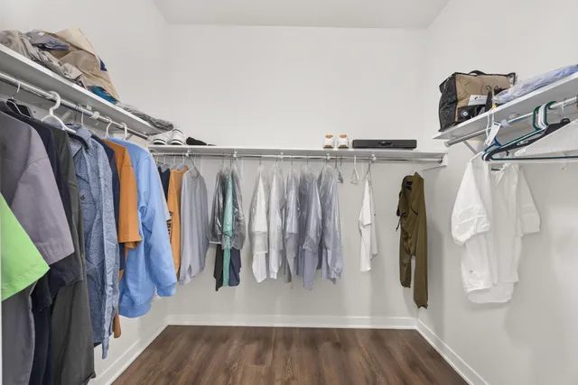 a view of walk in closet with clothes and shoes