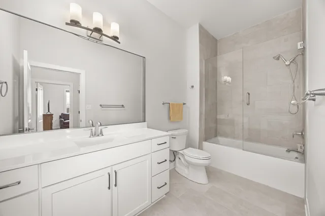 a bathroom with a double vanity sink toilet mirror and shower