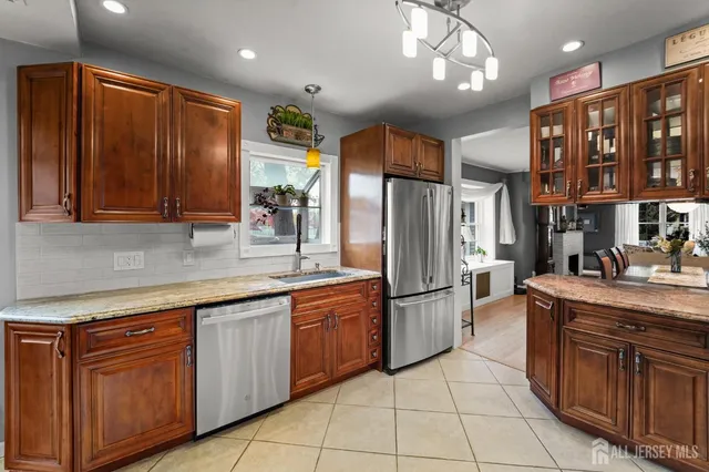 a kitchen with stainless steel appliances granite countertop a refrigerator and a sink