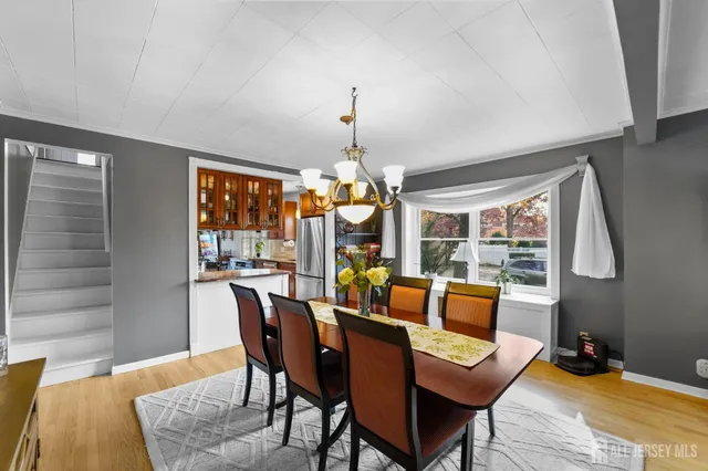 a dining room with furniture wooden floor a rug and a chandelier