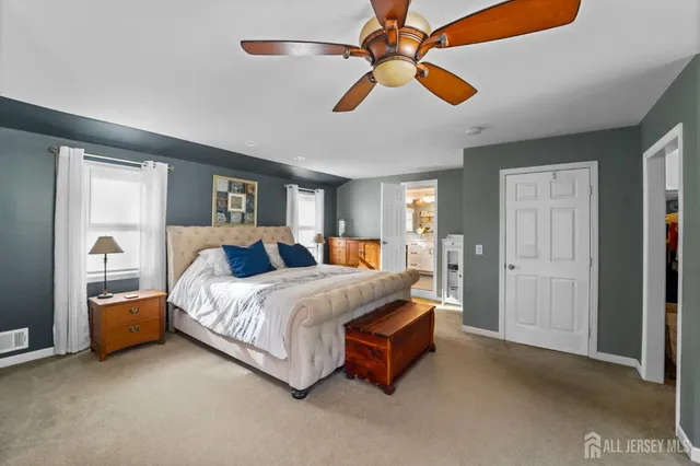 a spacious bedroom with a bed and a chandelier