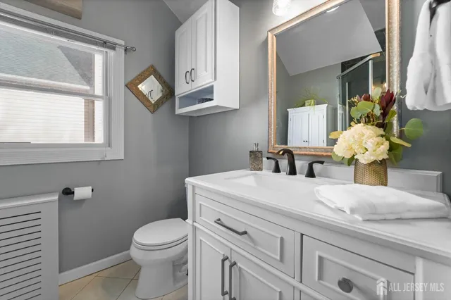a bathroom with a granite countertop toilet sink and mirror