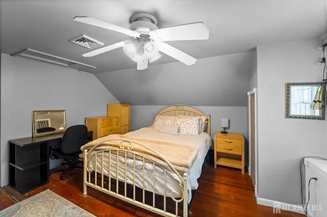 a bedroom with a bed a chandelier and a dresser