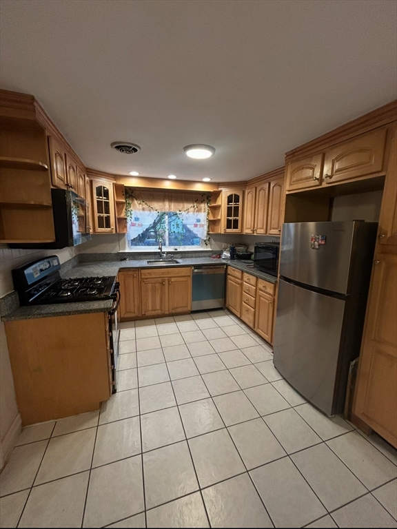 a kitchen with granite countertop a refrigerator and a stove top oven