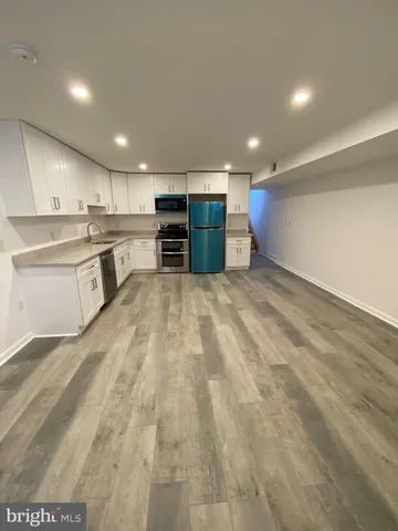 a large kitchen with kitchen island a sink stainless steel appliances and cabinets