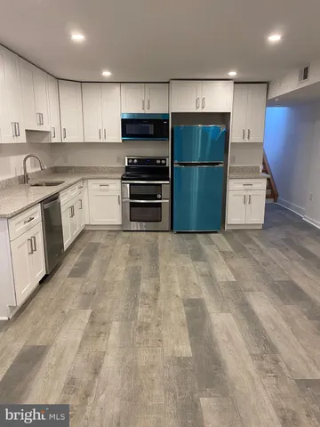 a kitchen with granite countertop a refrigerator and a sink