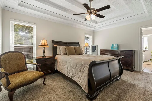 a bedroom with a bed a couch and a chandelier