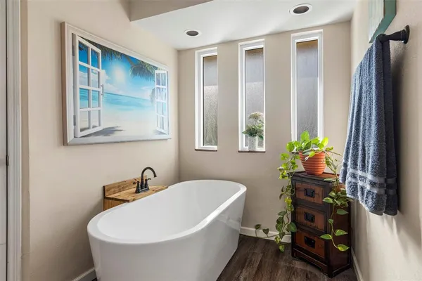 a white bath tub sitting next to a blue sink