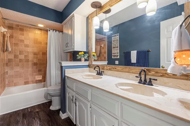 a bathroom with a double vanity sink toilet and shower