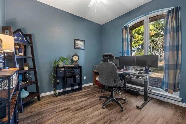 a view of a workspace with furniture and a window
