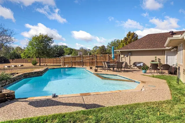a view of a swimming pool with lawn chairs and a fire pit