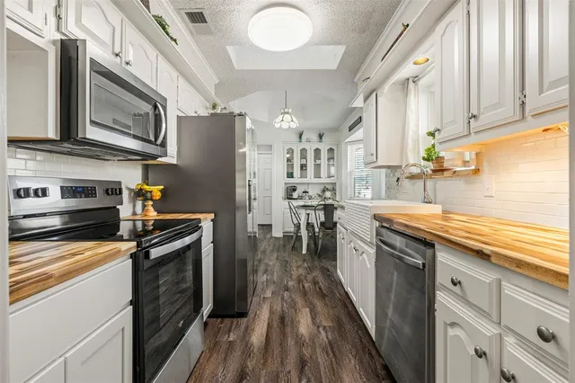 a kitchen with stainless steel appliances granite countertop a refrigerator a stove and a sink