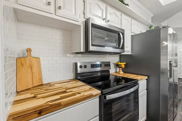 a kitchen with stainless steel appliances granite countertop a stove microwave and refrigerator