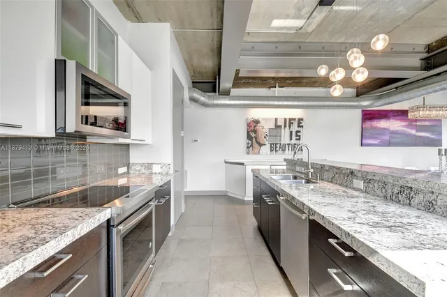 a kitchen with stainless steel appliances granite countertop a sink and stove