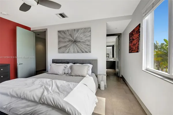 a bedroom with a large bed and a chandelier