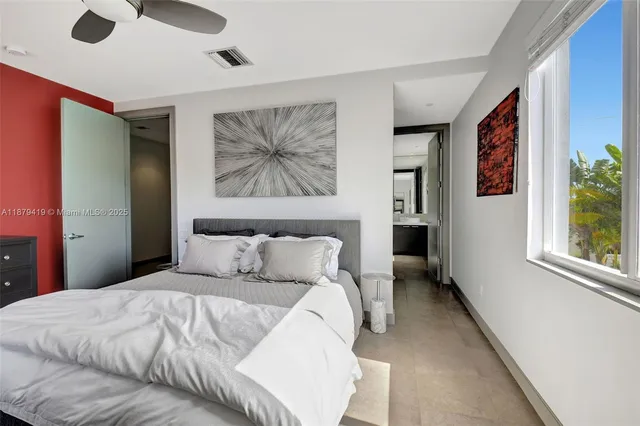 a bedroom with a large bed and a chandelier