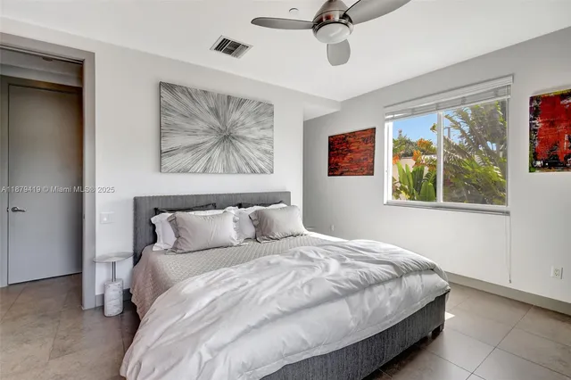 a bedroom with a bed and a painting on the wall