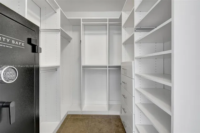 a view of walk in closet with empty racks