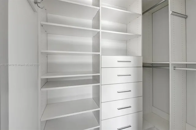 a view of walk in closet with empty racks