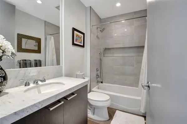 a bathroom with a granite countertop sink toilet and shower