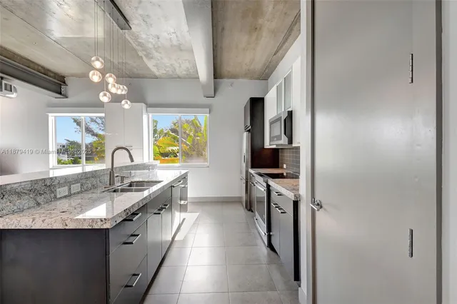 a kitchen with stainless steel appliances granite countertop a sink and a stove
