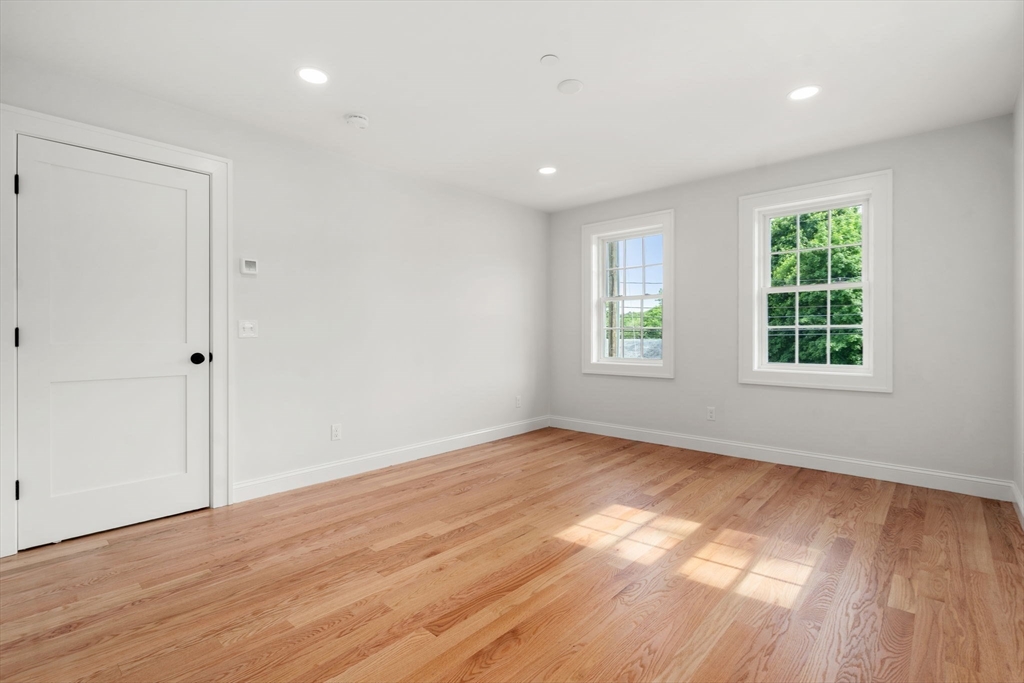 97 Bacon Street, Unit B Natick, MA 01760 - Photo 16 of 37 an empty room with wooden floor and windows