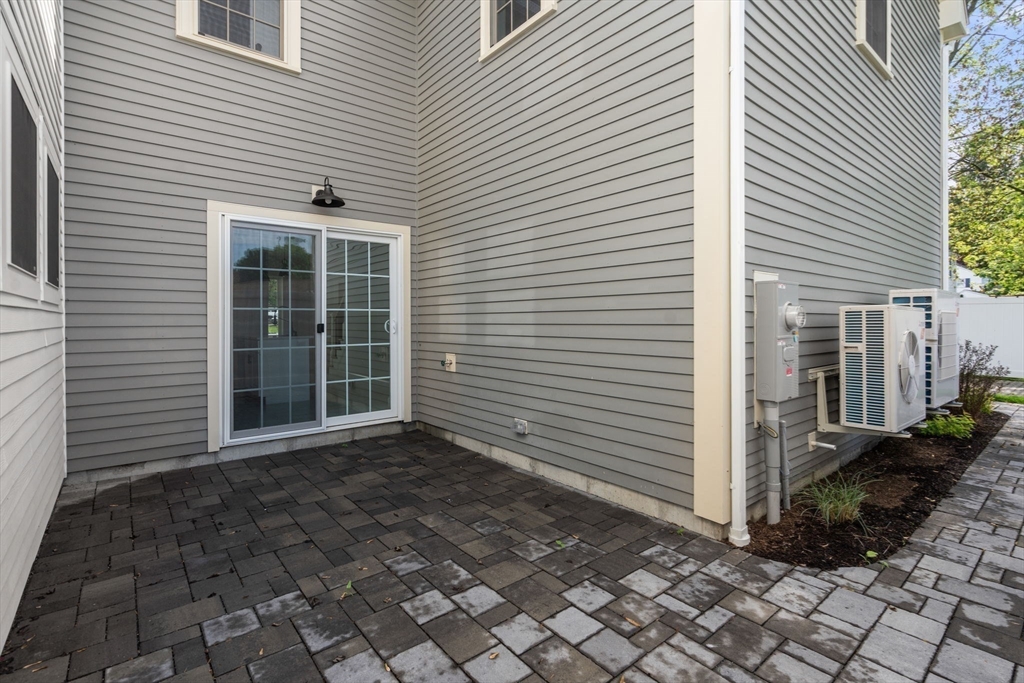 97 Bacon Street, Unit B Natick, MA 01760 - Photo 18 of 37 a view of a house with backyard and a white roof