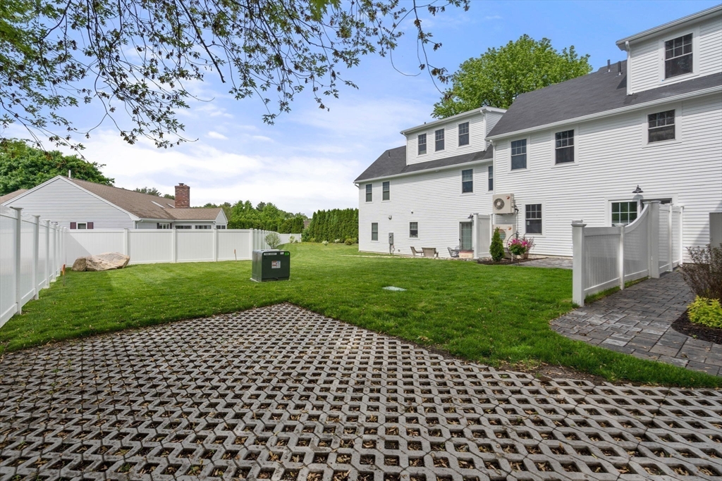 97 Bacon Street, Unit B Natick, MA 01760 - Photo 22 of 37 a view of a white house with a yard