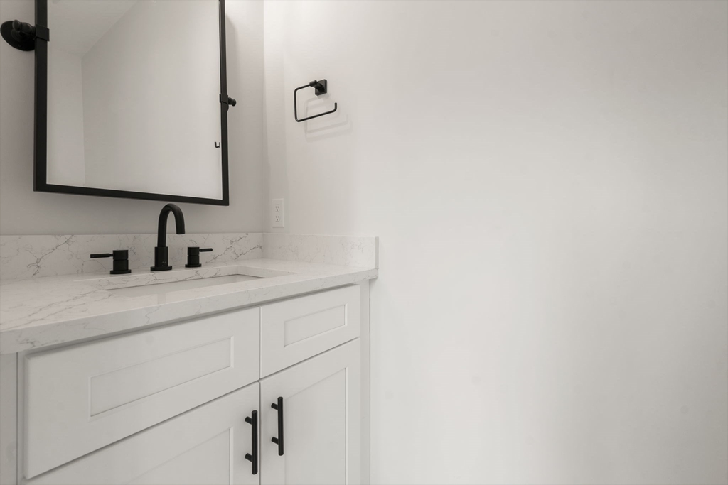 97 Bacon Street, Unit B Natick, MA 01760 - Photo 28 of 37 a bathroom with a sink and a mirror