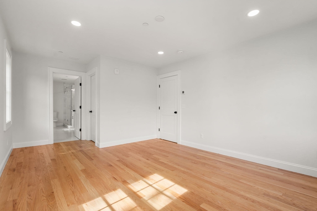 97 Bacon Street, Unit B Natick, MA 01760 - Photo 30 of 37 a bedroom with a bed and a night stand