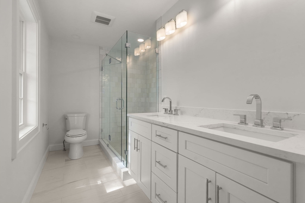 97 Bacon Street, Unit B Natick, MA 01760 - Photo 31 of 37 a spacious bathroom with a toilet sink and mirror