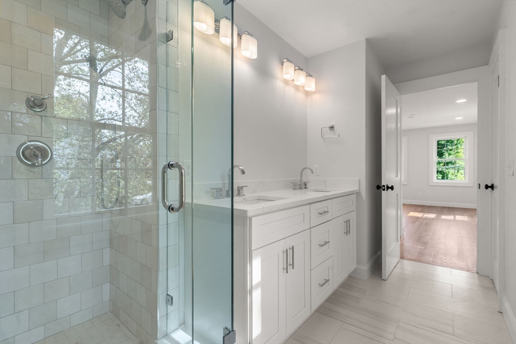 97 Bacon Street, Unit B Natick, MA 01760 - Photo 32 of 37 a spacious bathroom with a double vanity sink a large mirror and shower