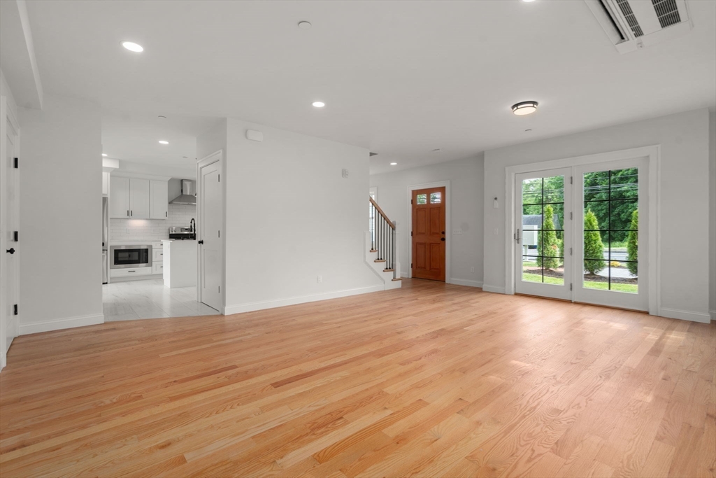 97 Bacon Street, Unit B Natick, MA 01760 - Photo 6 of 37 a view of empty room with wooden floor and windows