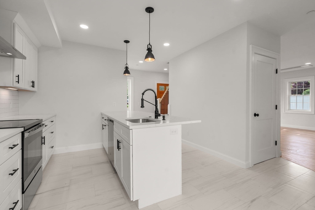 97 Bacon Street, Unit B Natick, MA 01760 - Photo 7 of 37 a kitchen with a sink and a stove top oven