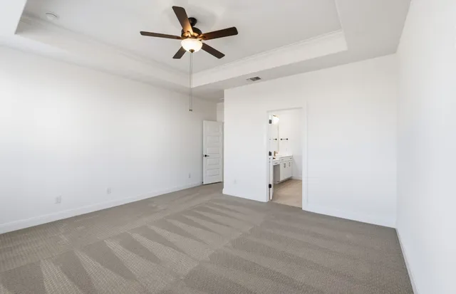 a view of empty room with wooden floor and ceiling fan