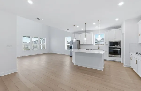 a kitchen with stainless steel appliances kitchen island granite countertop a refrigerator a sink and a stove