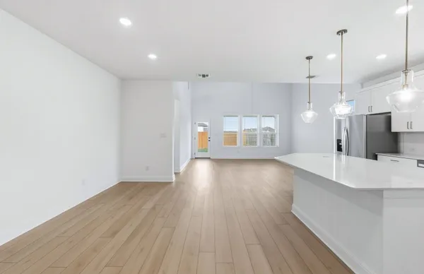 a large kitchen with kitchen island a sink a center island stainless steel appliances and a window