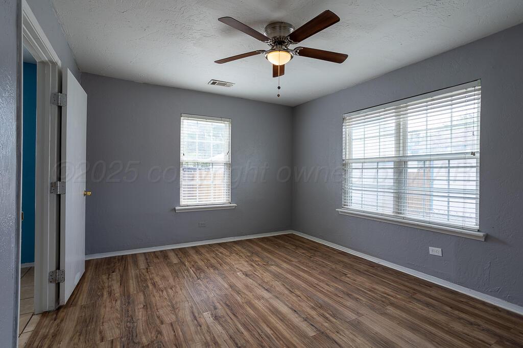 4105 Gables Street Amarillo, TX 79110 - Photo 11 of 18 a view of an empty room with wooden floor and a window