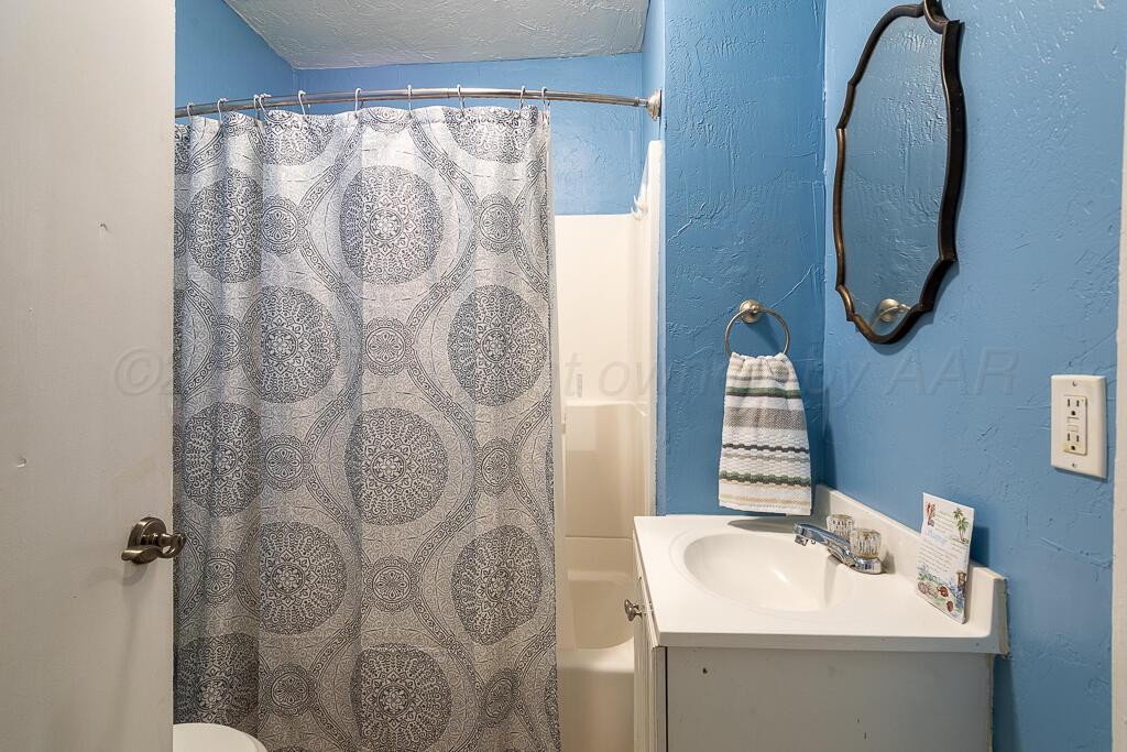 4105 Gables Street Amarillo, TX 79110 - Photo 13 of 18 a bathroom with a sink and mirror with shower