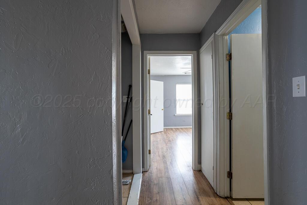 4105 Gables Street Amarillo, TX 79110 - Photo 14 of 18 a view of a hallway with wooden floor and a glass door