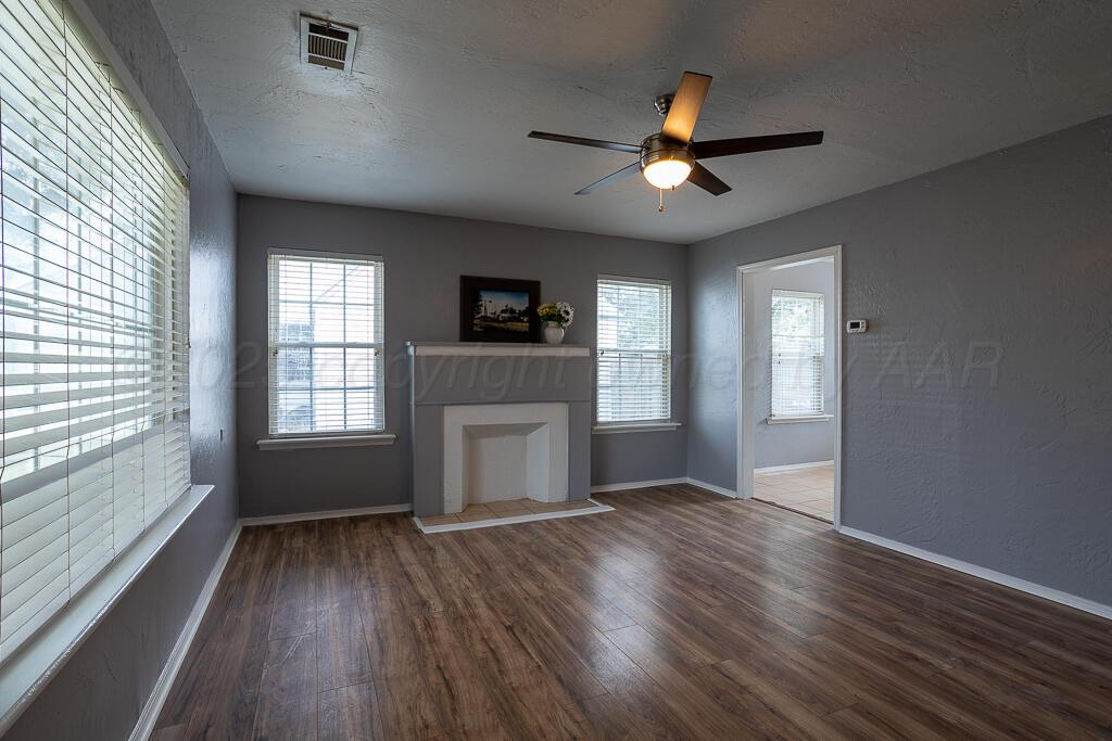 4105 Gables Street Amarillo, TX 79110 - Photo 2 of 18 a view of an empty room with a window and wooden floor