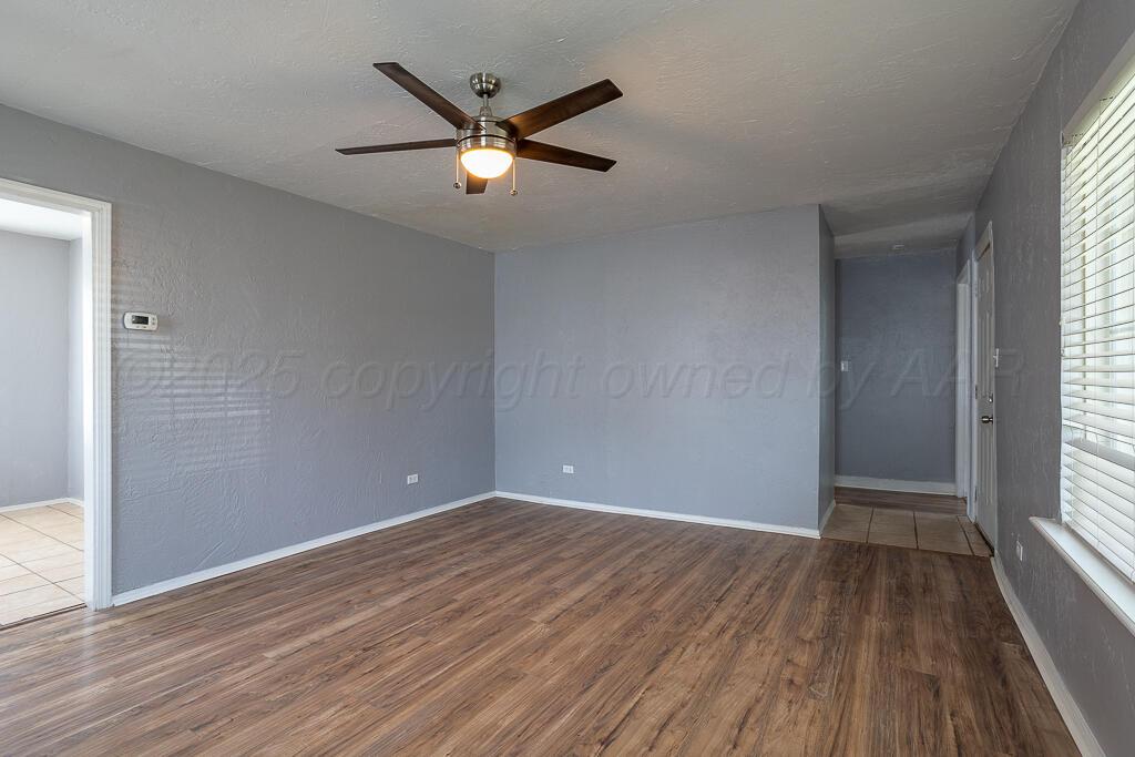 4105 Gables Street Amarillo, TX 79110 - Photo 4 of 18 wooden floor in an empty room with a window