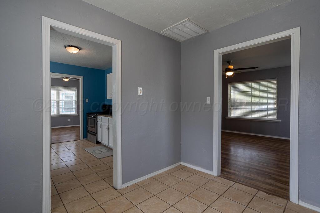 4105 Gables Street Amarillo, TX 79110 - Photo 6 of 18 a view of a hallway with wooden floor and a living room