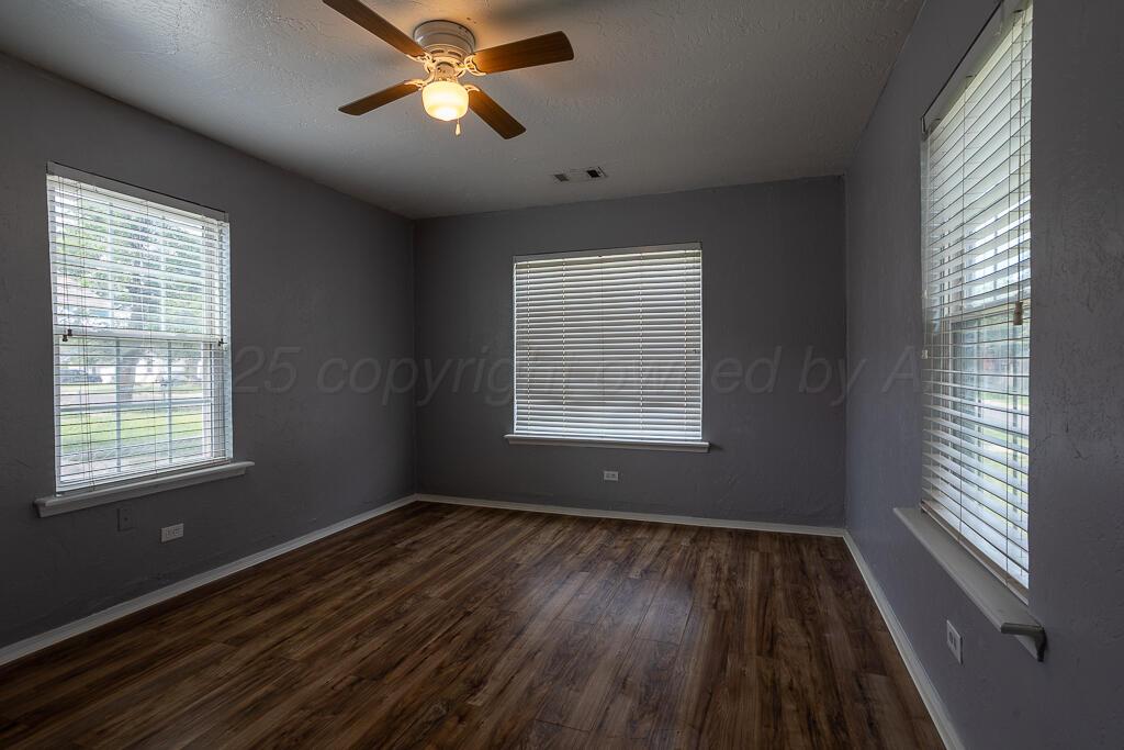 4105 Gables Street Amarillo, TX 79110 - Photo 9 of 18 a view of an empty room with wooden floor and a window