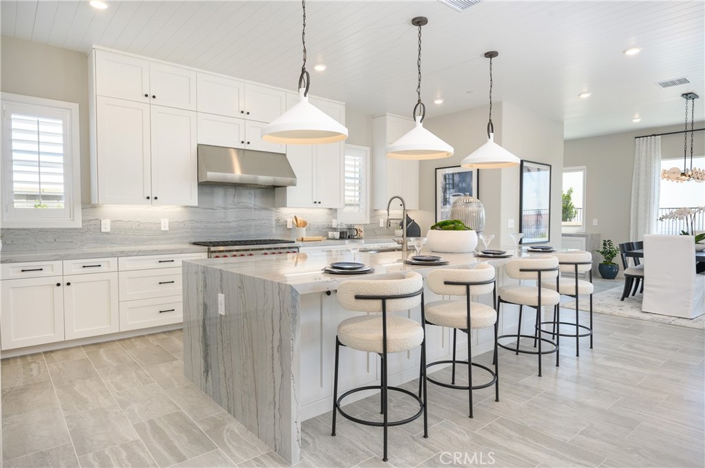 13093 Edgware Drive Rancho Cucamonga, CA 91739 - Photo 2 of 25 a kitchen with stainless steel appliances kitchen island granite countertop a stove a sink and white cabinets with wooden floor