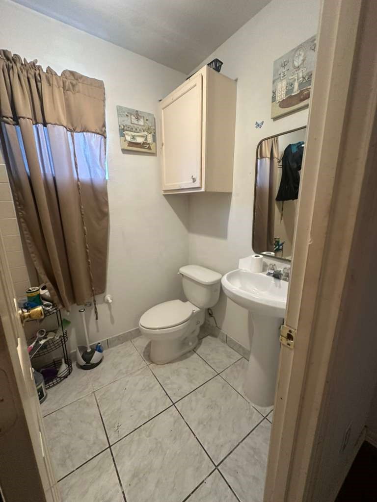 8404 Leander Street Houston, TX 77012 - Photo 16 of 28 a bathroom with a sink a toilet and a mirror