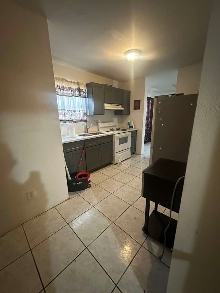 8404 Leander Street Houston, TX 77012 - Photo 8 of 28 a kitchen with a sink a stove a refrigerator and cabinets