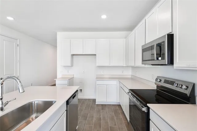 a kitchen with a sink stove top oven and cabinets