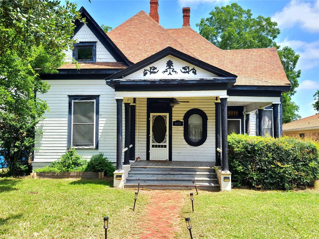 615 West Gandy Street Denison, TX 75020 - Photo 2 of 20 View of front facade featuring covered porch, a front yard, a chimney, and a shingled roof