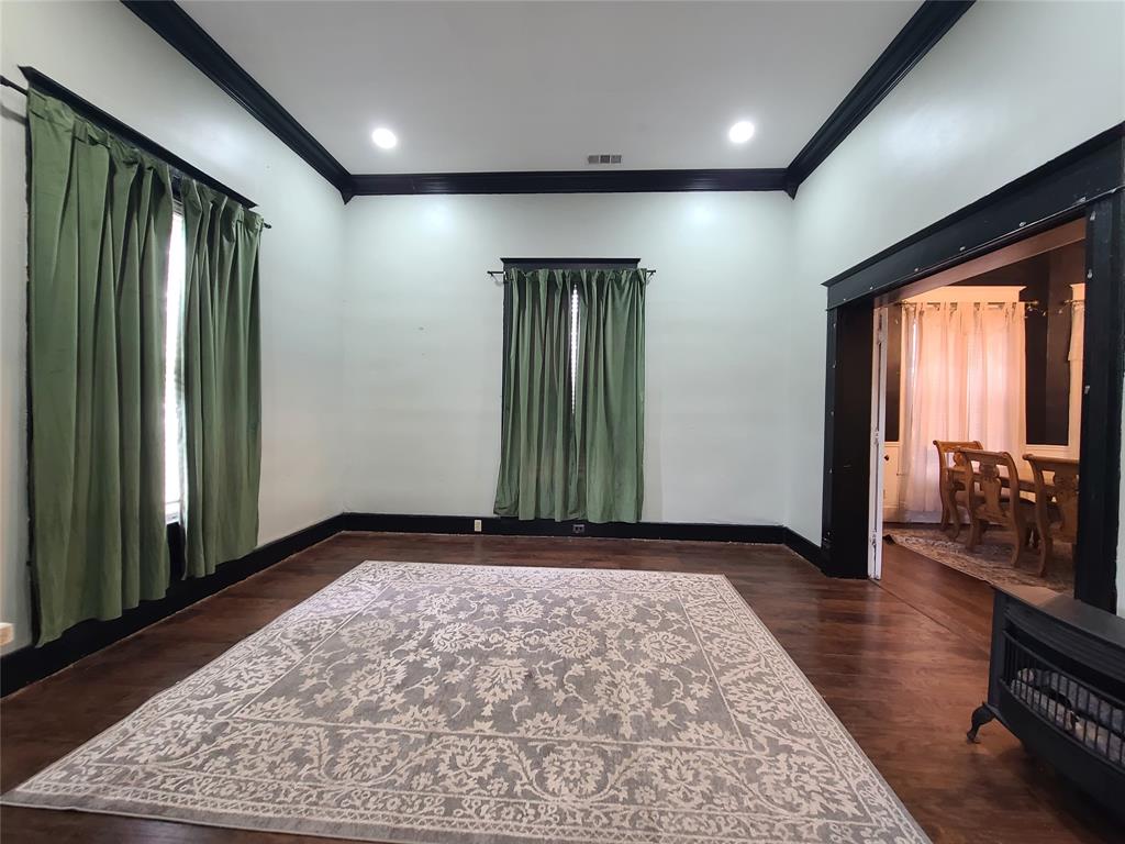 615 West Gandy Street Denison, TX 75020 - Photo 6 of 20 Spare room with crown molding and dark wood-style floors
